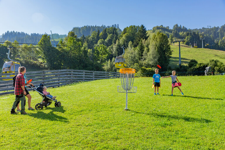 Familie mit Kinderwagen und Kindern vor Disc-Golf Korb | © Hauser Kaibling@René Eduard Perhab