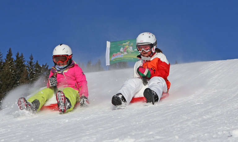 Zwei Kinder auf Zipfelbobs.  | © Tritscherhof